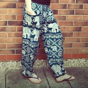 May include: Harem trousers with a blue and white elephant pattern. These loose-fitting trousers have a drawstring waist and pockets. The fabric is lightweight, ideal for warmer weather. The trousers are approximately 102 cm long.