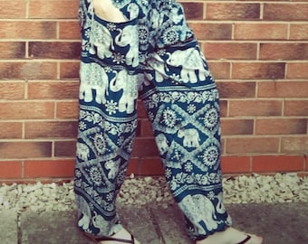 May include: Blue and white patterned harem pants featuring an elephant design. The pants have a relaxed fit with a drawstring waist and pockets. The fabric is lightweight, suitable for warm weather. The pants are approximately 40 inches long.