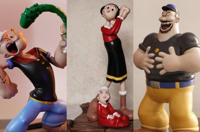 May include: Three cartoon figurines of Popeye, Olive Oyl, and Bluto. Popeye is holding a green spinach can and laughing. Olive Oyl is standing with her arms crossed and a baby in her arms. Bluto is laughing with his hands on his stomach.