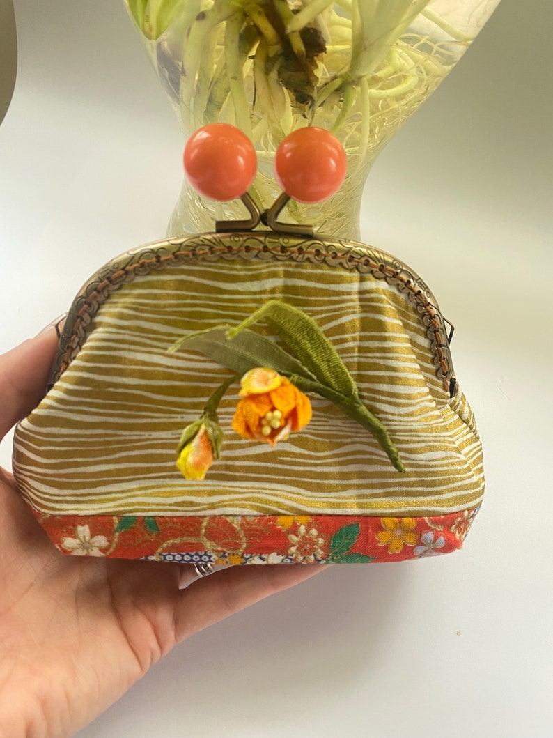 Oranje Kiss-lock-etui met Kanzashi-bloemdecoratie. afbeelding 3