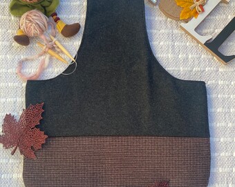 May include: A gray and brown fabric tote bag with a checkered pattern. The bag has a wide opening and a flat bottom.