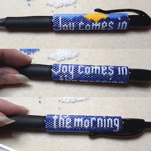May include: A blue and white beaded pen with the text "Joy comes in the morning" on it.