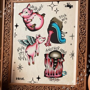 May include: A framed art print featuring tattoo-style illustrations. The artwork includes pink pigs, a shoe, and a trash can with a raccoon. Text includes "To the fullest," "Stick with it," "Never say never," "Another man's trash," and "inkrat."