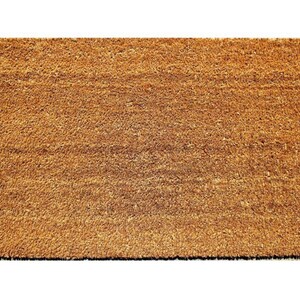 Puede incluir: Una alfombra de coco marr&oacute;n con una superficie texturizada.