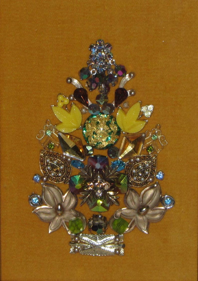 May include: A gold, green, and yellow jeweled Christmas tree ornament made of various vintage buttons and rhinestones.