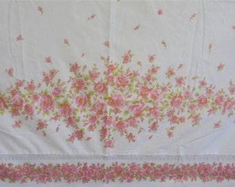May include: White fabric with a pink floral pattern. The fabric has a border of smaller pink flowers.