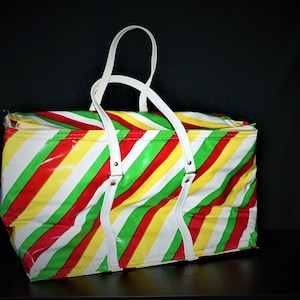 May include: A large, white vinyl tote bag with red, yellow, and green diagonal stripes. The bag has two white handles.