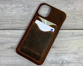May include: Brown leather phone case with a built-in card slot. The case has a distressed look and a stitched edge.