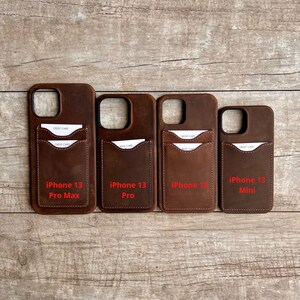 Op de afbeelding: Vier bruine leren telefoonhoesjes met kaartsleuven. De hoesjes zijn gelabeld met "iPhone 13 Pro Max", "iPhone 13 Pro", "iPhone 13" en "iPhone 13 Mini".