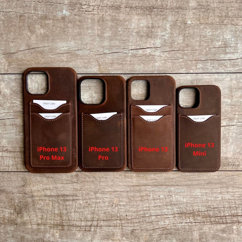 Op de afbeelding: Vier bruine leren telefoonhoesjes met kaartsleuven. De hoesjes zijn gelabeld met "iPhone 13 Pro Max", "iPhone 13 Pro", "iPhone 13" en "iPhone 13 Mini".