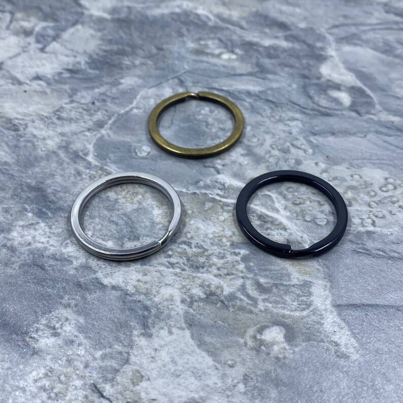 Peut inclure: Trois porte-cl&eacute;s de finitions diff&eacute;rentes&nbsp;: argent, noir et or. Les porte-cl&eacute;s sont tous de la m&ecirc;me taille et de la m&ecirc;me forme.