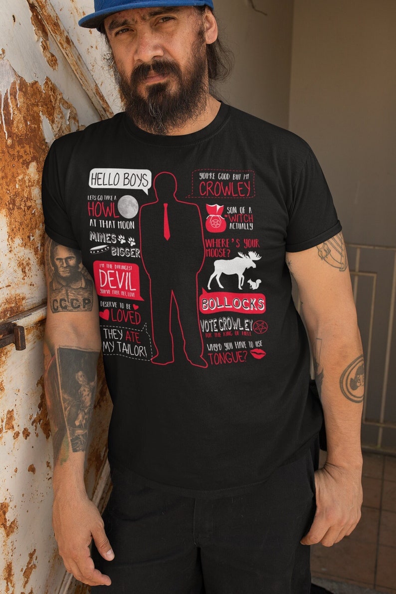 May include: Black t-shirt with a red silhouette of a man wearing a tie and a red quote bubble. The quote bubble says "Hello Boys". The t-shirt has red text with quotes from the TV show Supernatural. The text includes "Let's go take a howl at that moon", "Mines bigger", "I'm the darkness, don't take it lightly", "Devil", "Deserve to be loved", "They ate my tailor", "You're good but I'm Crowley", "Son of a witch actually", "Where's your moose?", "Bollocks", "Vote Crowley for the King of Hell", "Why'd you have to use tongue?"