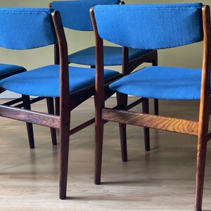 K&ouml;nnte beinhalten: Vier Esszimmerst&uuml;hle aus dunklem Holz mit blauen Stoffbez&uuml;gen. Die St&uuml;hle haben ein modernes Design aus der Mitte des Jahrhunderts.