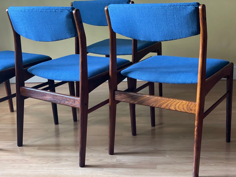 K&ouml;nnte beinhalten: Vier Esszimmerst&uuml;hle aus dunklem Holz mit blauen Stoffbez&uuml;gen. Die St&uuml;hle haben ein modernes Design aus der Mitte des Jahrhunderts.