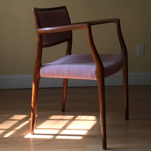 Peut inclure: Une chaise en bois avec un si&egrave;ge et un dossier en tissu rose clair. La chaise a un dossier et des accoudoirs incurv&eacute;s, et les pieds sont effil&eacute;s.