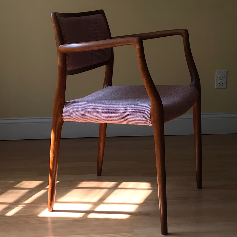 Peut inclure: Une chaise en bois avec un si&egrave;ge et un dossier en tissu rose clair. La chaise a un dossier et des accoudoirs incurv&eacute;s, et les pieds sont effil&eacute;s.