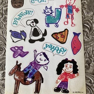 May include: A sheet of stickers with colorful, childlike illustrations. The stickers include a dog, cat, pizza slice, fish, and a person riding a horse. Speech bubbles say "cool!", "bow wow!", and "yahoo!" The text "MY FAVORITE THINGS" is at the top.