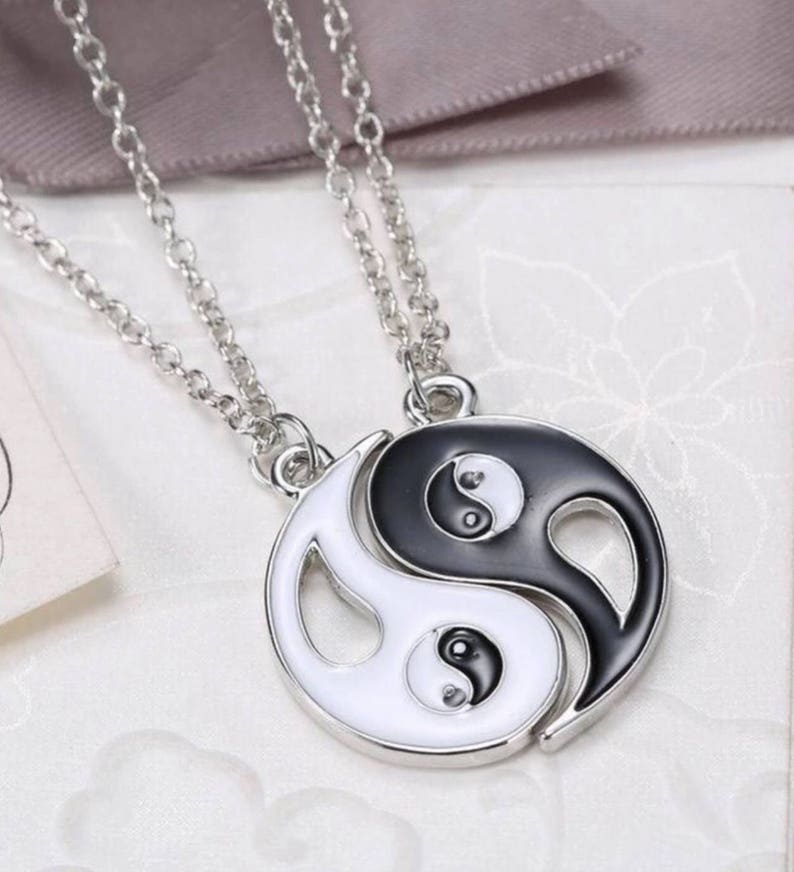 A Pair of Ying and Yang Necklaces on 18 Inch Chains.