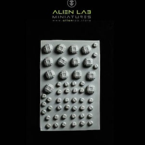 Op de afbeelding: Een siliconen mal met een raster van 3D-vormen, waaronder cirkels, vierkanten en koepels. De mal is grijs en heeft een glad oppervlak. De tekst "ALIEN LAB MINIATURES www.alienlab.store" is op de mal gedrukt.