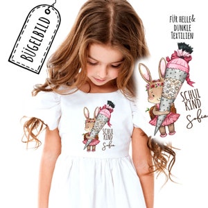 May include: Iron-on patch featuring a cartoon bunny holding a decorated cone with the text "Schul Kind Sofia". The patch is suitable for light and dark fabrics.