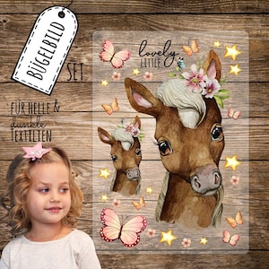 Può includere: Un set di trasferimenti da stirare con due puledri marroni con fasce floreali, farfalle e stelle. Il testo "lovely little" è incluso nel trasferimento.