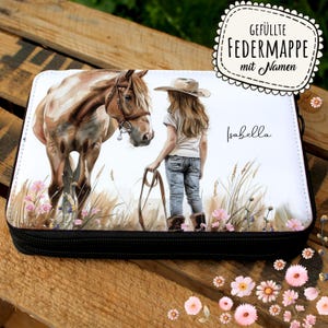 Könnte beinhalten: Weißes Federmäppchen mit schwarzem Reißverschluss, das eine Aquarellillustration eines Pferdes und eines Mädchens mit Cowboyhut zeigt. Der Text "Isabella" ist auf dem Etui geschrieben. Der Text "GEFÜLLTE FEDERMAPPE mit Namen" ist sichtbar.