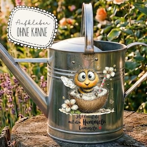Puede incluir: Una regadera de metal plateado con una calcomanía de abeja de dibujos animados. La abeja está en una cáscara de coco con una flor y una pajita a rayas. El texto de la calcomanía dice "Aufkleber OHNE KANNE" y "Jetzt kannst du mit den Hummeln bummeln".