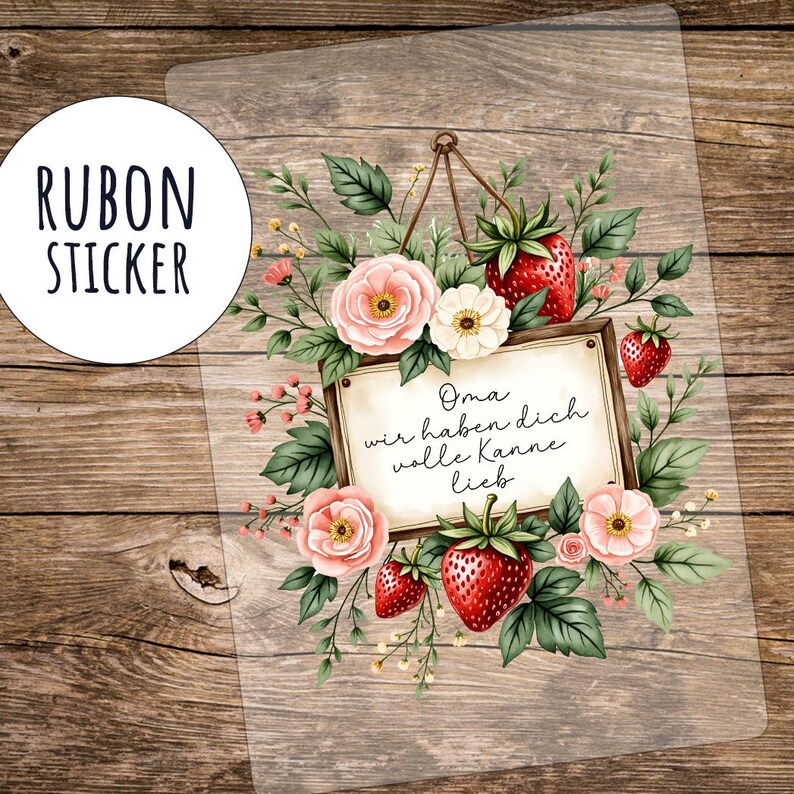 May include: A clear sticker with a floral design featuring pink roses, white flowers, and red strawberries. The sticker has the text "Oma wir haben dich volle Kanne lieb" in a wooden frame. The sticker also has the text "RUBON STICKER" in a white circle.