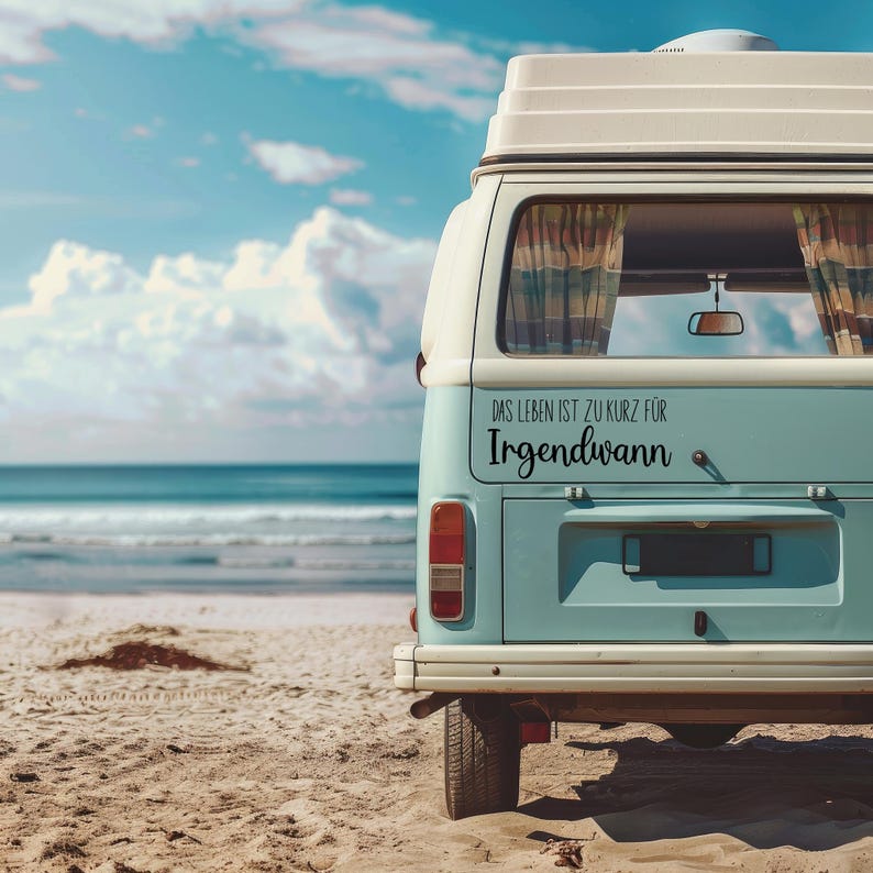 May include: A blue and white vintage camper van parked on a sandy beach. The back window has a black vinyl sticker that reads "Das Leben ist zu kurz f&uuml;r Irgendwann".