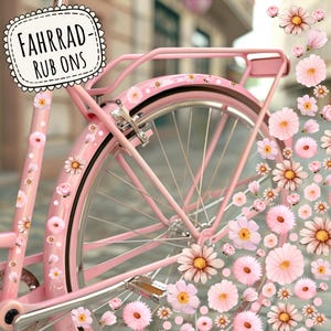 Peut inclure: Un vélo rose avec un panier blanc et un motif floral sur les pneus. Le vélo porte une pancarte qui dit "Fahrrad-Rub Ons".