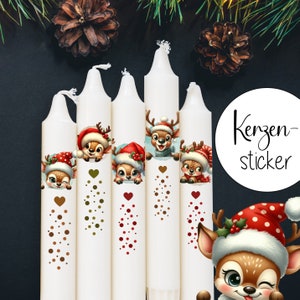 Puede incluir: Cinco velas blancas con diseños festivos de renos. Cada vela presenta un reno diferente con un gorro de Papá Noel rojo y blanco. Las velas están decoradas con lunares dorados y rojos. El texto "Kerzen-sticker" es visible en un círculo blanco.