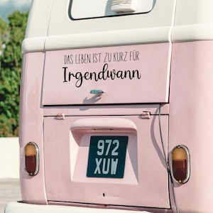 May include: A pink vintage van with a black sticker that reads "Das Leben ist zu kurz f&uuml;r Irgendwann". The van has a license plate that reads "972 XUW".