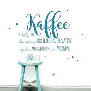 Może przedstawiać: Nalepka ścienna w kolorze turkusowym z niemieckim słowem "Kaffee" napisanym ozdobnym pismem. Tekst pod słowem "Kaffee" brzmi "('KAFE), DER: die warme, KÖSTLICHE ALTERNATIVE zu den MORDGELÜSTEN am MORGEN." Dwa białe ceramiczne kubki stoją na niebieskim drewnianym stołku.