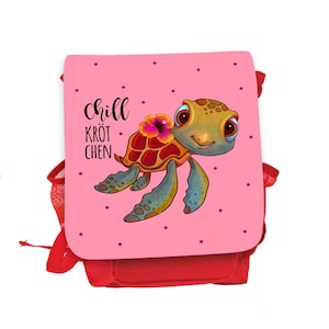 Könnte beinhalten: Ein rosa Rucksack mit rotem Besatz und einer Comic-Schildkröte mit einer Blume auf dem Kopf. Der Rucksack trägt den Text "chill kröt chen".