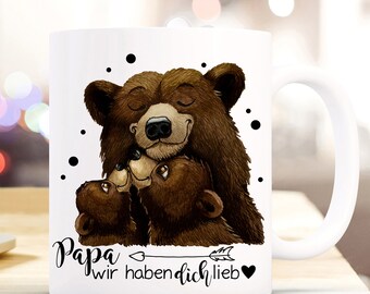 May include: White ceramic mug with a brown bear illustration. The bear is hugging two smaller bears. The text "Papa wir haben dich lieb" is printed on the mug.