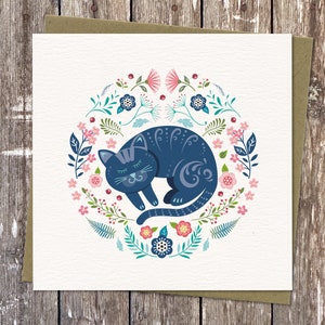 Colourful Cat illustration in my circular Nordic folk art style. It features a sleeping cat surrounded by flowers, ferns and leaves in  blues, pinks and turquoise. Square Card with Brown Eco Envelope.