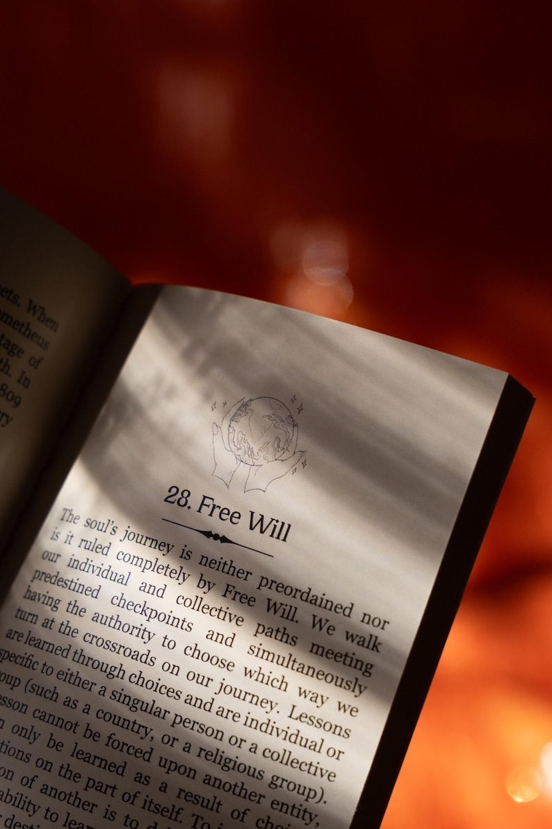 May include: Open book page with the title "28. Free Will". The page features text about the soul's journey and free will, with an illustration of hands holding a globe. The background is a warm, reddish-orange.