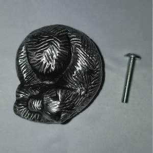 Könnte beinhalten: Ein silberner Metall-Schrankknauf in Form einer schlafenden Katze. Der Knauf wird mit einer silbernen Schraube geliefert.