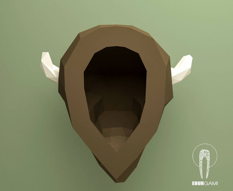 May include: A brown papercraft model of a bison head with white paper horns. The model is designed to be assembled by hand.