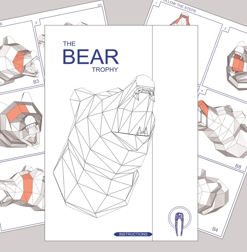 May include: A black and white line drawing of a bear head trophy. The bear's mouth is open and its teeth are visible. The drawing is on a white background with the text "THE BEAR TROPHY" above the drawing and "INSTRUCTIONS" below the drawing.