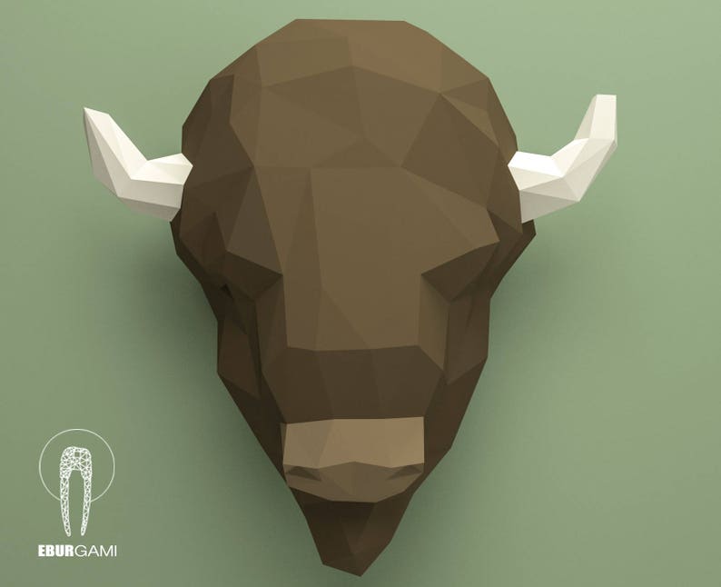 May include: A brown papercraft bison head with white horns. The bison head is made of folded paper and has a geometric design.