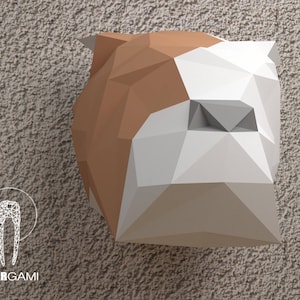 May include: An origami bulldog head, made of paper, in white and brown, against a textured background.