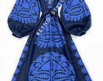 May include: A navy blue linen dress with blue embroidered floral patterns. The dress has a cinched waist with a tie and long sleeves. The dress has the text "#ETNO_STYLEINUA" on the side.