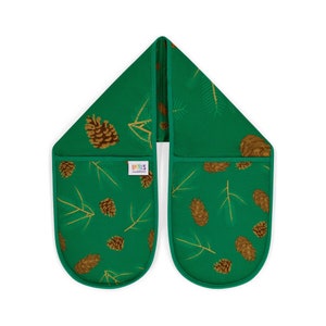 May include: A pair of green oven mitts with a pine cone and pine needle pattern. The mitts are connected by a long strip of fabric. The mitts have the text "LPXIES" on them.