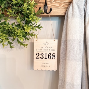 May include: Wooden sign with the text "there's no place like home" and the address "23168 toano, virginia".