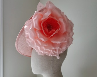 Könnte beinhalten: Ein rosa Stoffhut mit einer großen, rosa Stoffrose oben drauf. Der Hut sitzt auf einem weißen Mannequin-Kopf.
