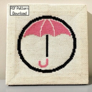 May include: A white canvas with a black circle containing a pink umbrella. The text "PDF Pattern Download" is in a black rectangle at the top of the canvas.