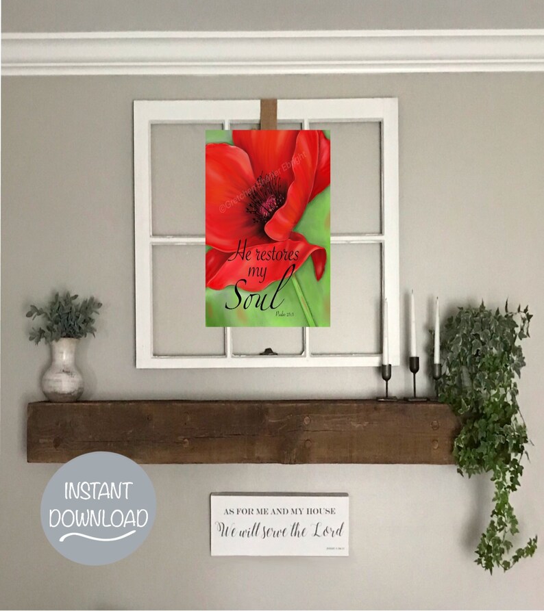 May include: A printable wall art design featuring a red poppy flower with a green stem and leaves. The text "He restores my Soul" is written in black cursive font with the scripture reference "Psalm 23:3". The design is framed in a white window frame and displayed on a wooden shelf with a green plant.