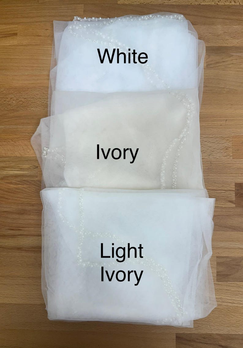May include: Three layers of sheer tulle fabric veils arranged vertically, each featuring a delicate beaded edge. The top layer is labelled White, the middle layer is labelled Ivory, and the bottom layer is labelled Light Ivory in black text.