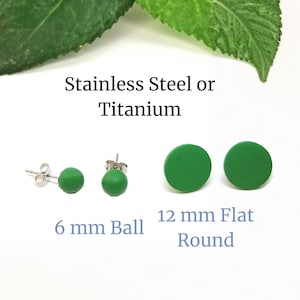 May include: Green stud earrings in two styles: 6 mm ball and 12 mm flat round. The earrings are available in stainless steel or titanium. The image includes text that reads "Stainless Steel or Titanium", "6 mm Ball", and "12 mm Flat Round".